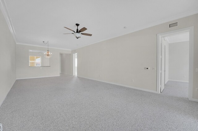 carpeted empty room featuring ceiling fan with notable chandelier, baseboards, visible vents, and crown molding