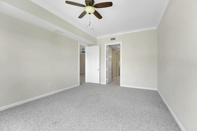 carpeted spare room featuring ceiling fan, baseboards, visible vents, and ornamental molding