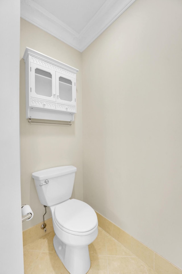 bathroom with tile patterned flooring, baseboards, ornamental molding, and toilet