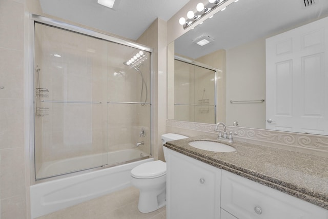 full bathroom with vanity, tile patterned flooring, bath / shower combo with glass door, and toilet