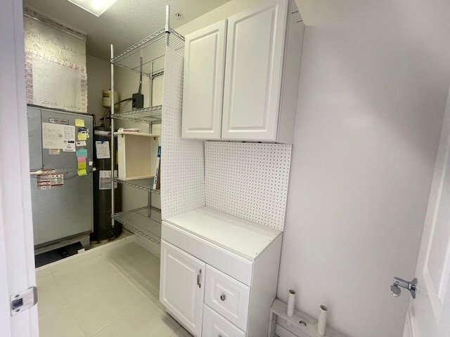 interior space with water heater and light tile patterned flooring