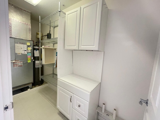 bathroom with water heater and tile patterned floors
