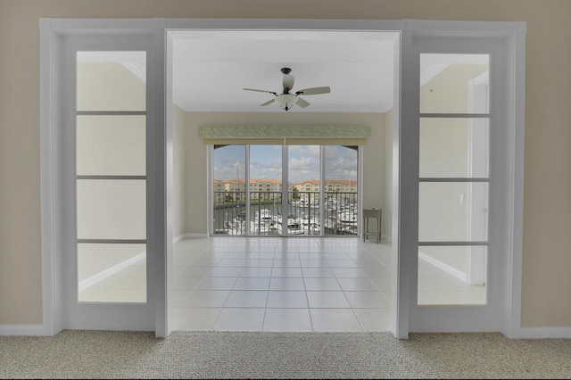 interior space with ceiling fan, baseboards, crown molding, and carpet