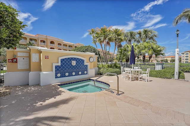 view of pool featuring fence, a hot tub, and a patio
