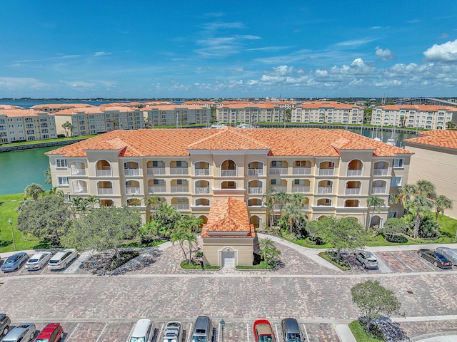 view of property with uncovered parking and a water view