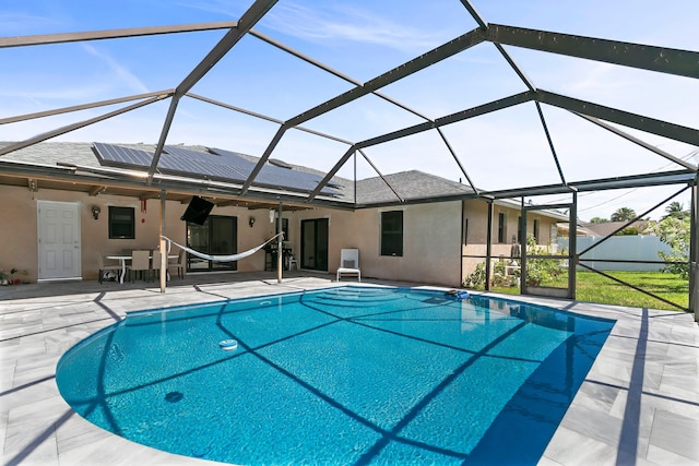 view of pool featuring glass enclosure and a patio