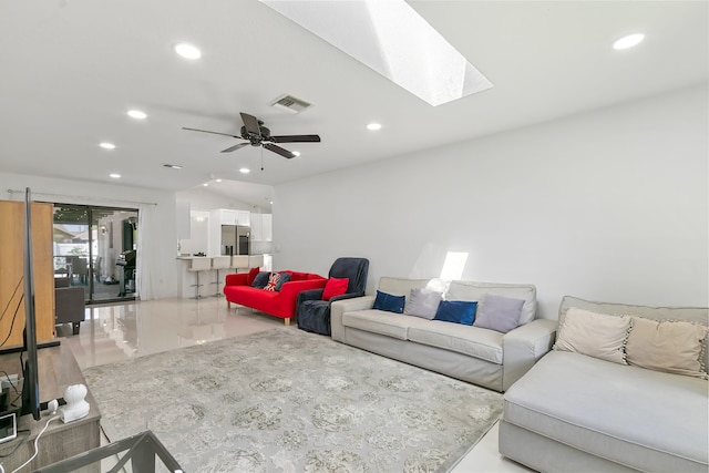 living room with ceiling fan and a skylight