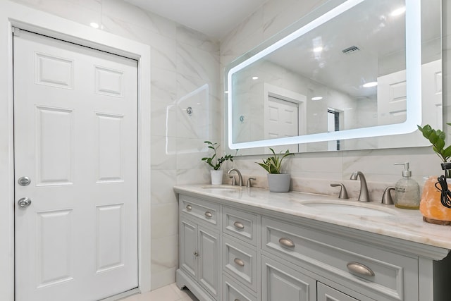 bathroom with vanity and tile walls