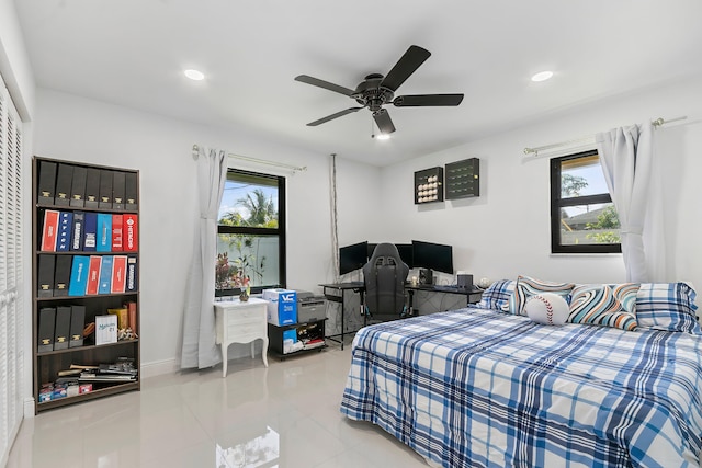 tiled bedroom with ceiling fan and multiple windows