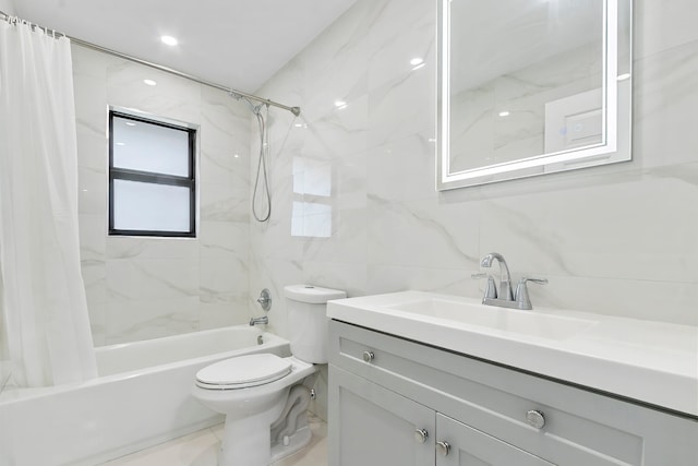 full bathroom with vanity, toilet, shower / bath combo with shower curtain, and tile walls