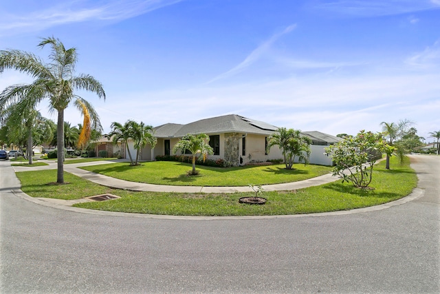 single story home featuring solar panels and a front lawn