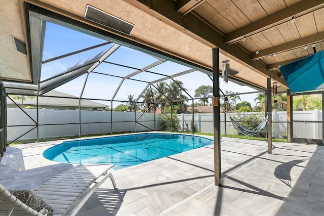 view of swimming pool featuring glass enclosure and a patio