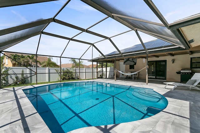 view of swimming pool featuring ceiling fan, a lanai, and a patio