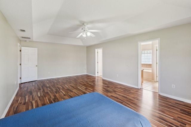 unfurnished room with ceiling fan, a raised ceiling, and hardwood / wood-style flooring