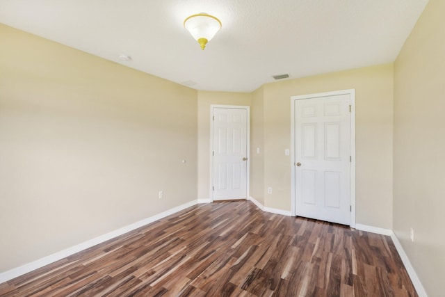 unfurnished bedroom with dark hardwood / wood-style floors