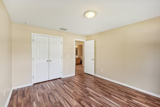 unfurnished bedroom featuring dark hardwood / wood-style flooring and a closet