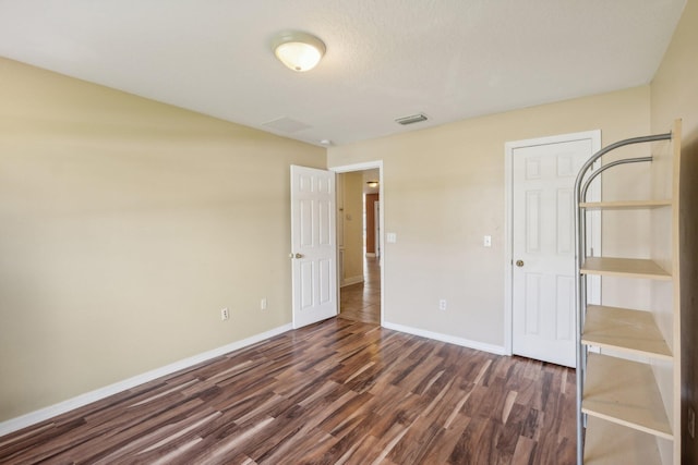 unfurnished bedroom with dark hardwood / wood-style floors