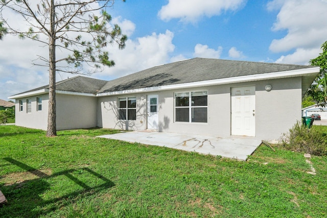 back of house with a lawn and a patio