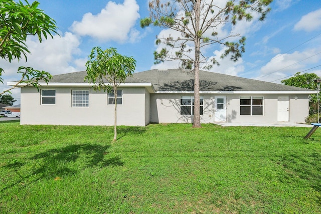 back of house with a yard and a patio