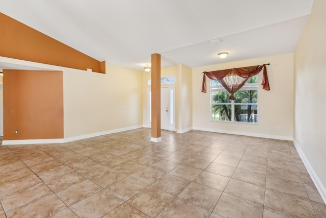 tiled spare room with lofted ceiling