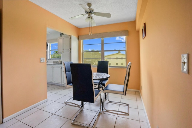 tiled dining room featuring ceiling fan and a textured ceiling