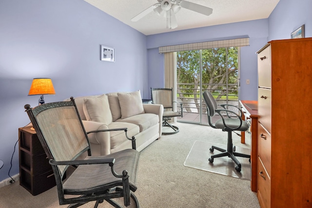 carpeted home office featuring a textured ceiling and ceiling fan