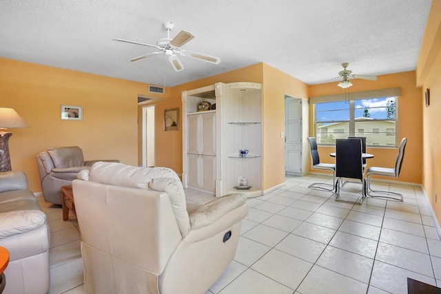 tiled living room featuring ceiling fan and a textured ceiling