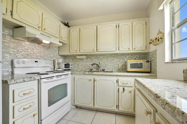 kitchen with white appliances, sink, light tile patterned floors, tasteful backsplash, and light stone counters