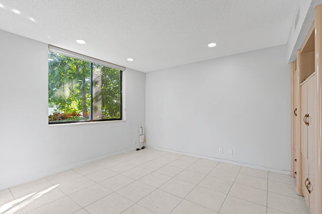 unfurnished bedroom featuring a textured ceiling and light tile floors