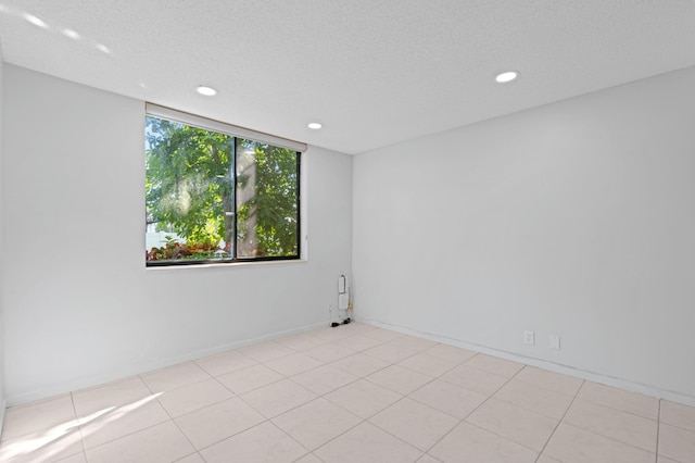 tiled spare room featuring a textured ceiling