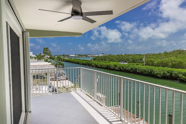 balcony with ceiling fan and a water view