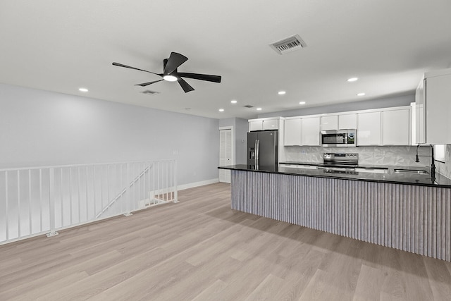 kitchen with stainless steel appliances, ceiling fan, light wood-type flooring, white cabinets, and sink