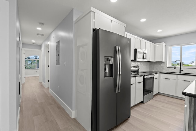 kitchen with sink, light wood-type flooring, a wealth of natural light, and stainless steel appliances