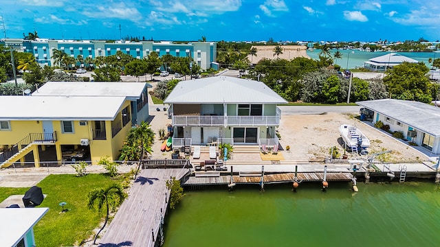 back of property featuring a water view and a patio area