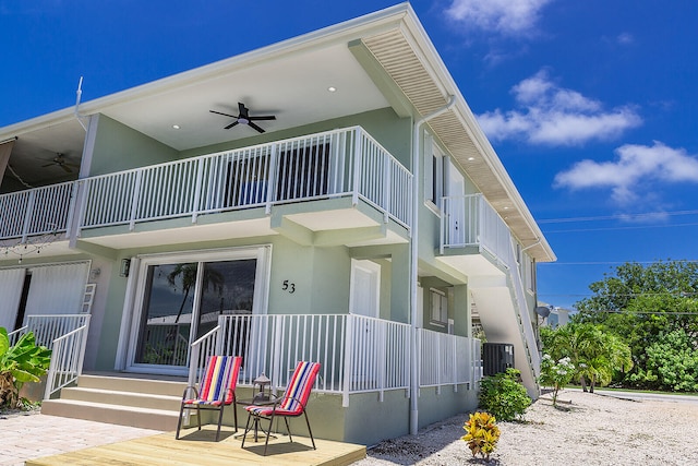 rear view of property with a balcony and ceiling fan