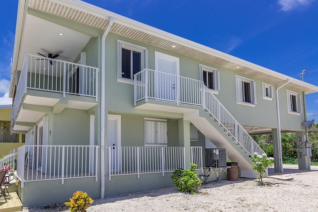 back of property with central AC and a balcony