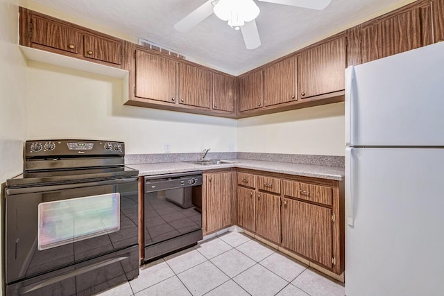 kitchen with black appliances, ceiling fan, light tile patterned floors, and sink