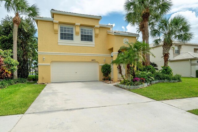 mediterranean / spanish-style house featuring a garage and a front yard