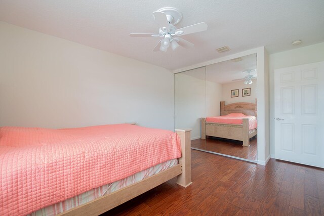 bedroom with a closet, ceiling fan, and dark hardwood / wood-style floors