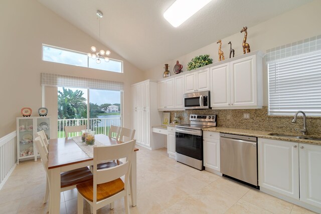 kitchen featuring tasteful backsplash, stainless steel appliances, light tile floors, sink, and white cabinets