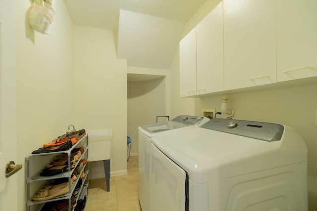 laundry room featuring washer and dryer, cabinets, light tile floors, and washer hookup