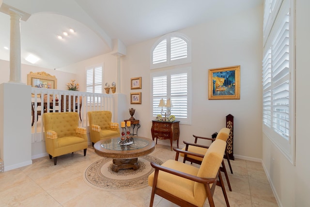 sitting room with decorative columns and light tile floors