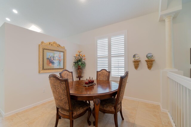 dining area featuring light tile flooring and ornate columns