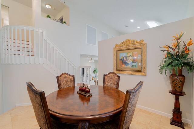 tiled dining space with a towering ceiling