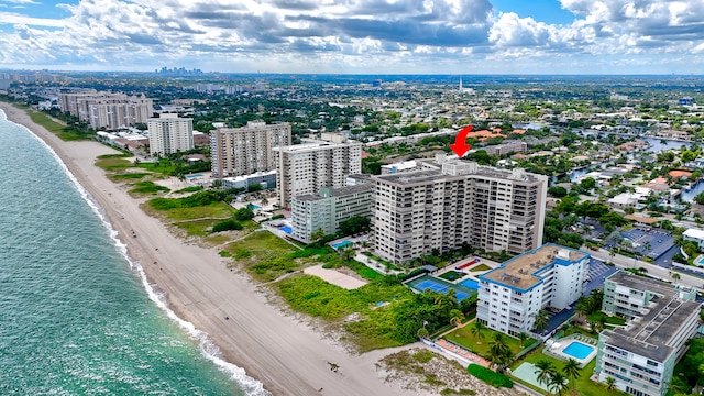 drone / aerial view featuring a beach view and a water view