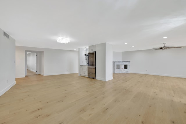 unfurnished living room featuring ceiling fan and light hardwood / wood-style flooring