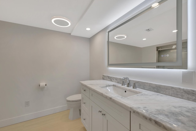 bathroom with vanity, wood-type flooring, and toilet