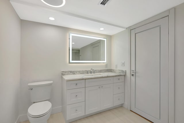 bathroom featuring toilet and vanity