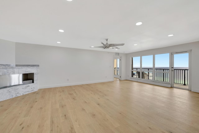 unfurnished living room with ceiling fan and light hardwood / wood-style floors