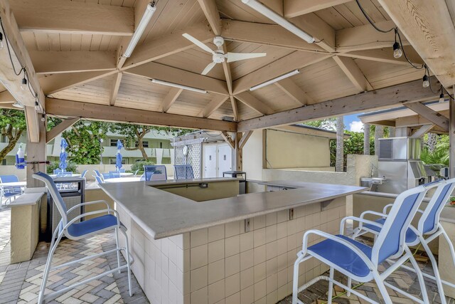 view of patio / terrace with exterior bar, area for grilling, a gazebo, and ceiling fan